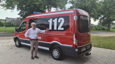 Bürgermeister Prof. Dr. Erhard Huzel vor dem neuen Mannschaftstransportwagen (MTW) der FF Lüdersdorf